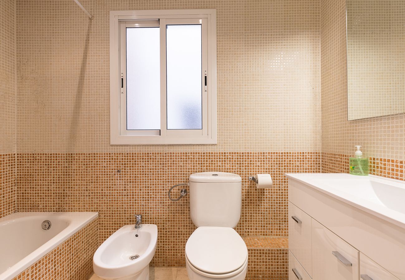 cuarto de baño con bañera, completo, práctico en la casa plaza españa barcelona