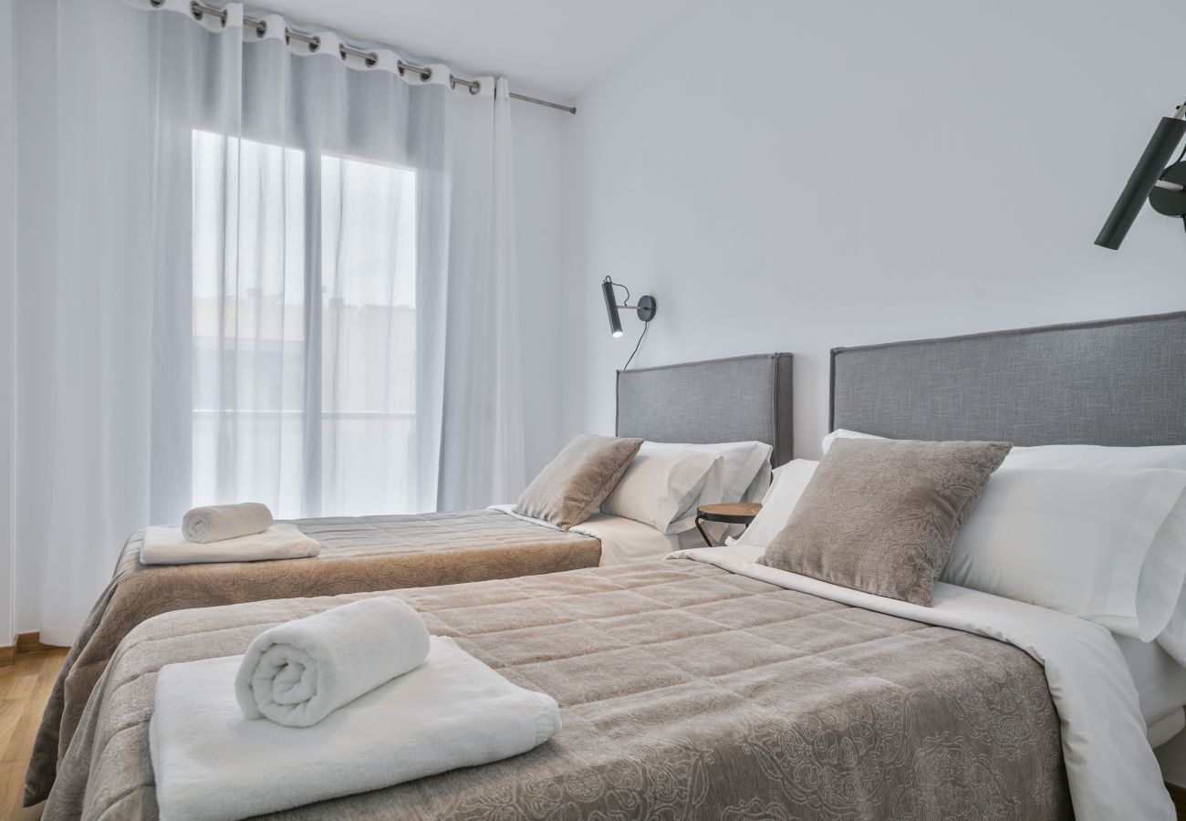 dormitorio principal con baño privado con bañera y armarios en apartamento superior en Barcelona