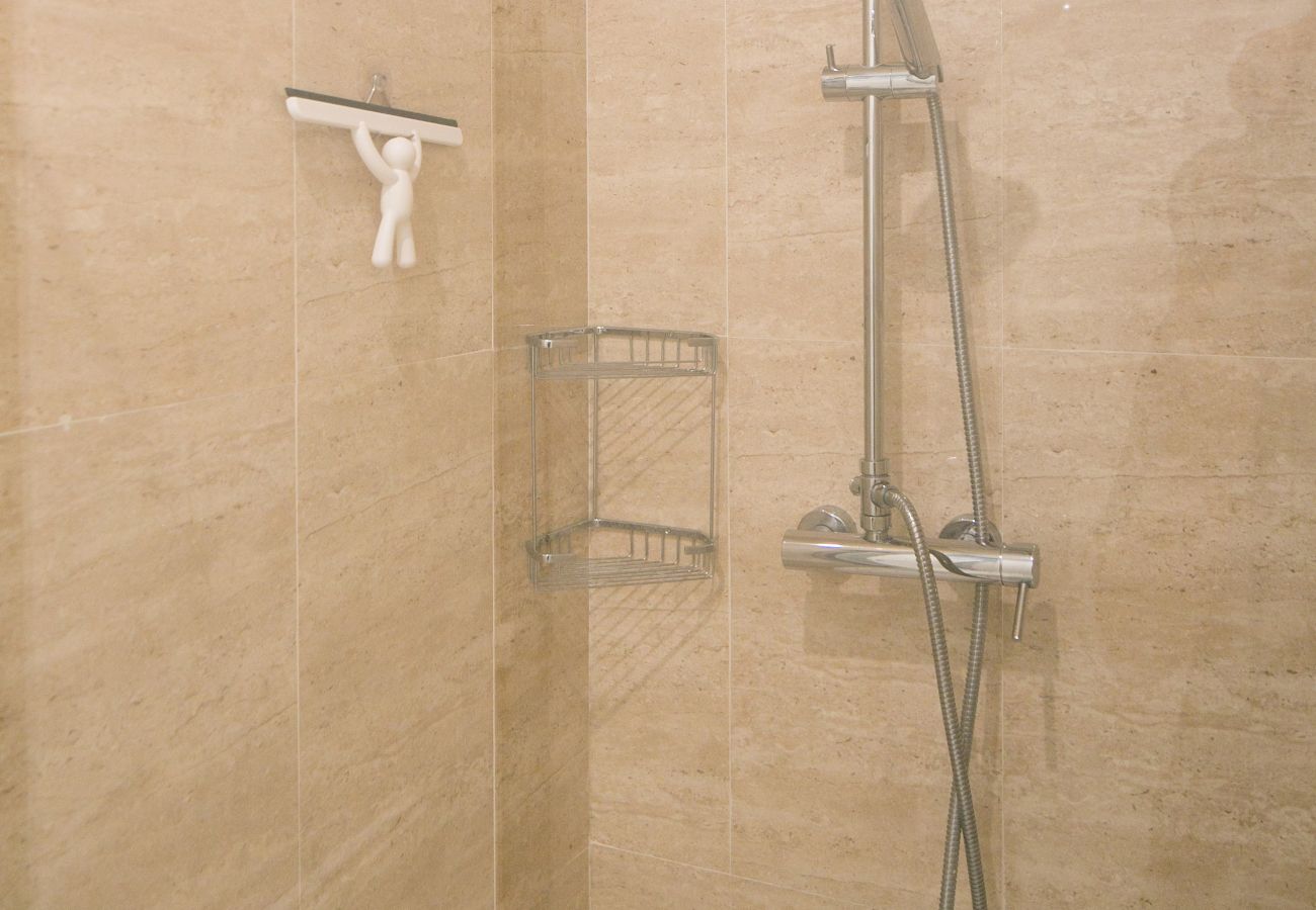 Douche spacieuse et moderne avec vasque, toilette et radiateur sèche-serviette