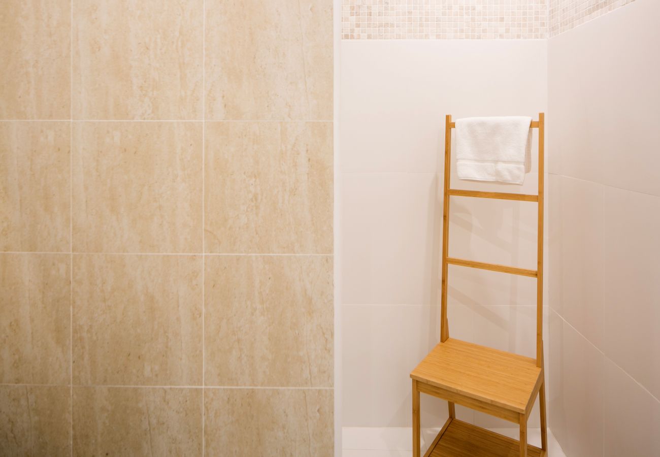 Sèche serviette devant une douche au coeur d’une salle de bain