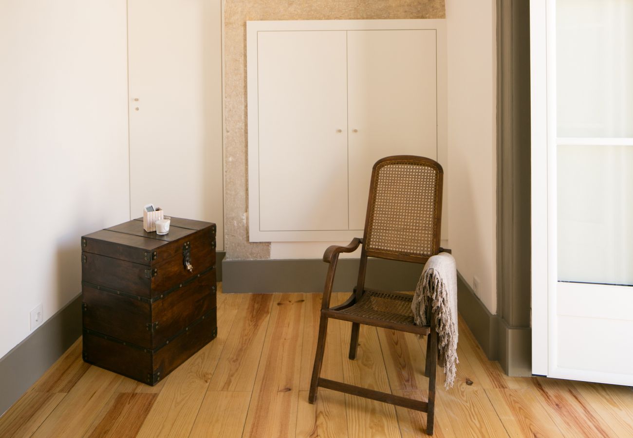 Décoration avec chaise rustique et table de chevet en bois devant une fenêtre