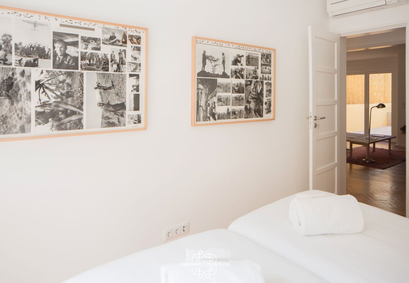 Chambre avec deux lits simples avec des photos historiques sur les murs