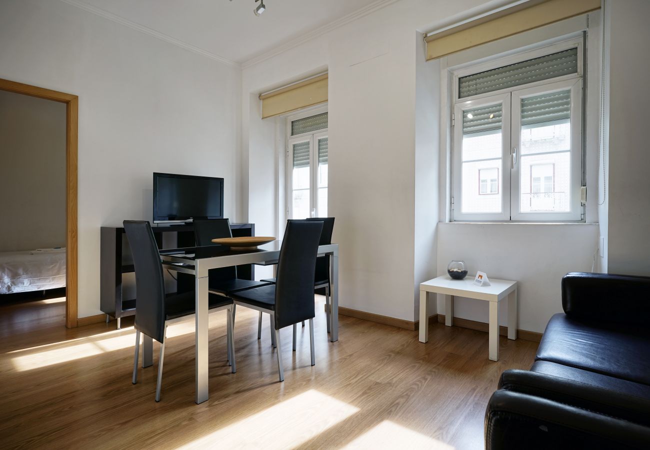 Salon baigné de lumière naturelle, télévision, table à manger et canapé-lit | Appartement 3 chambres Arroios Lisbonne